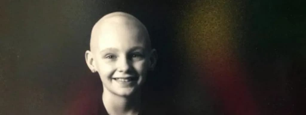 Riley Randoll smiling and holding her name sign